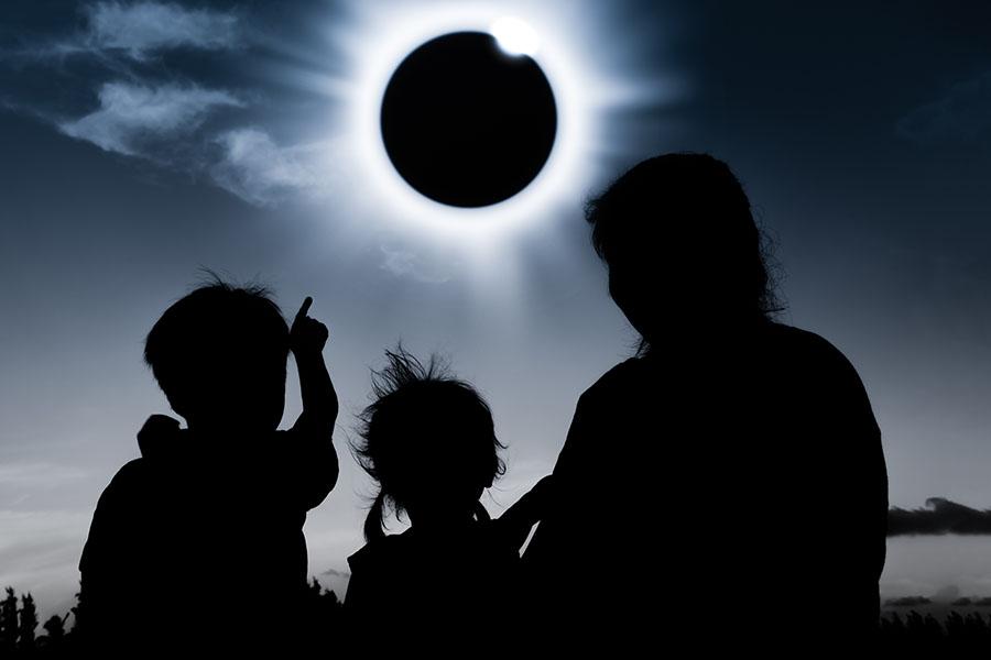 Adult and two children viewing eclipse