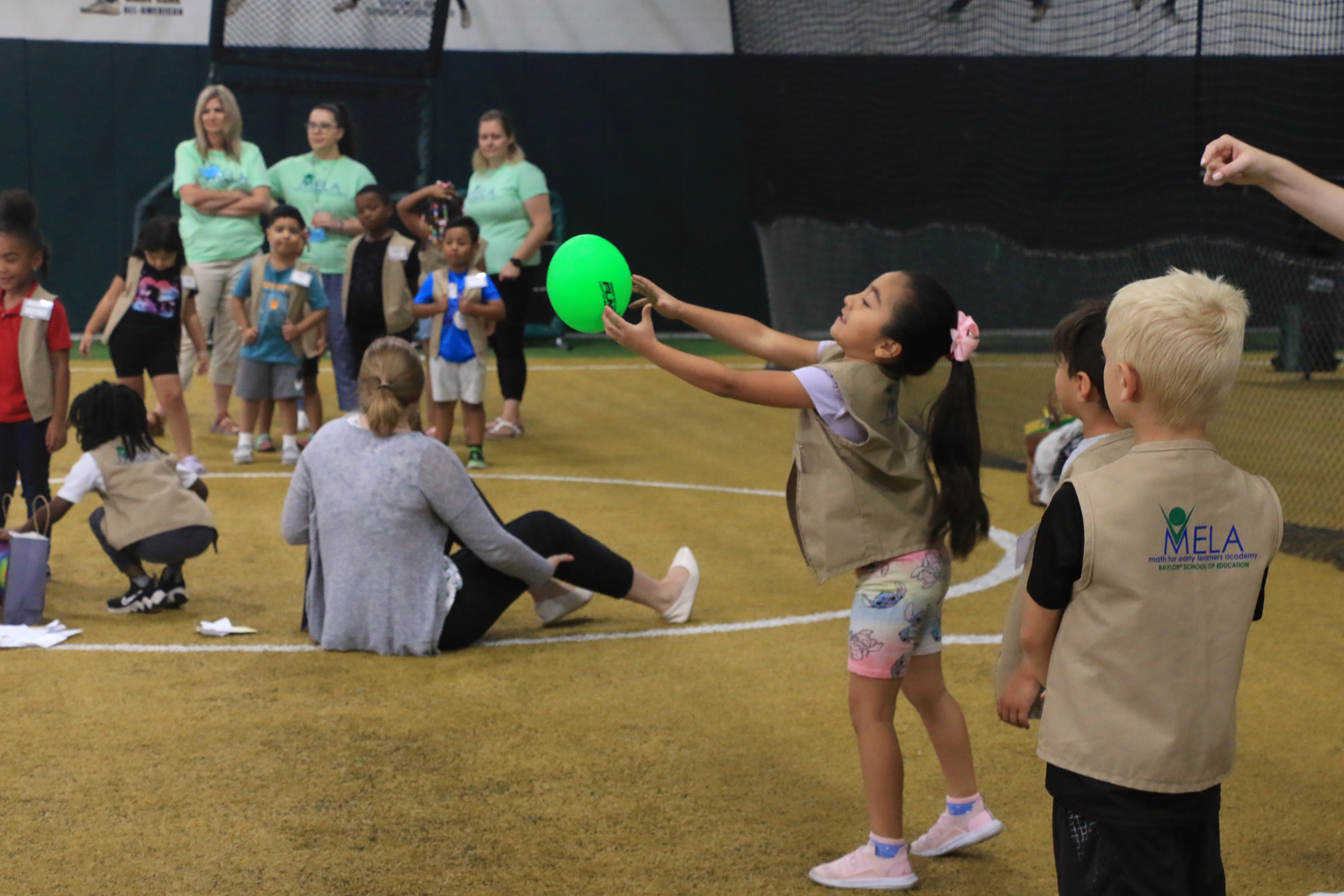 Student playing with Baylor athletes at Baylor Math for Early Learners Academy