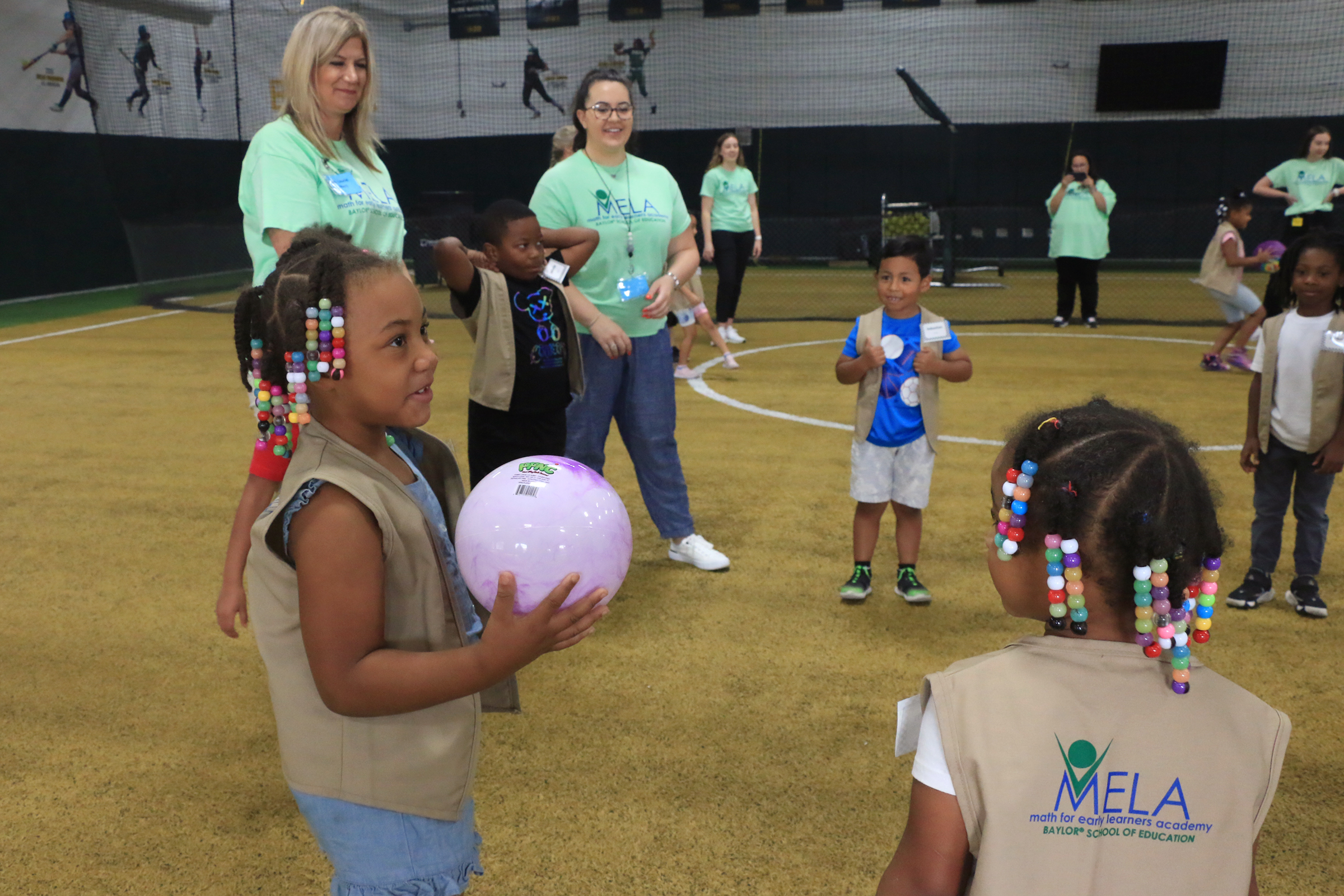 Student playing with Baylor athletes at Baylor Math for Early Learners Academy