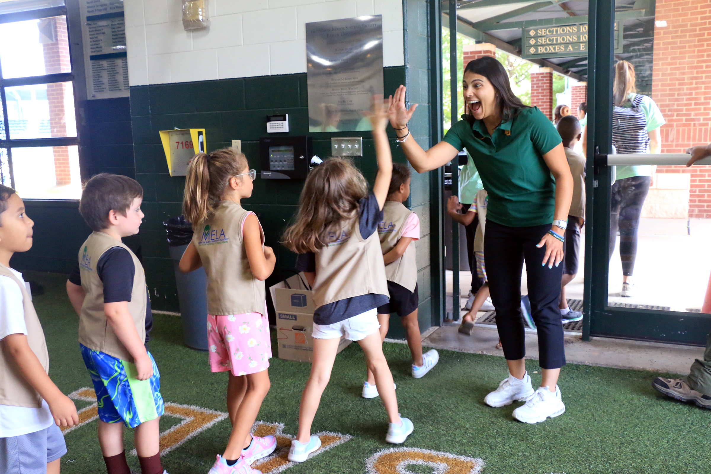 Student playing with Baylor athletes at Baylor Math for Early Learners Academy